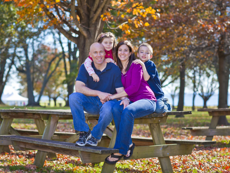 Family,Sitting,On,Bench,During,The,Fall